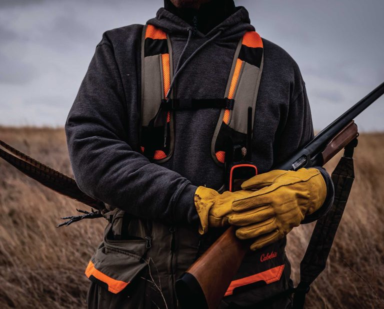 A bird hunter in a field hunting pheasant.