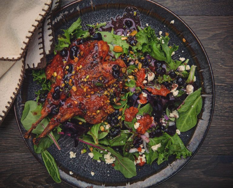 Firecracker chukar sits atop a bed of lettuce.