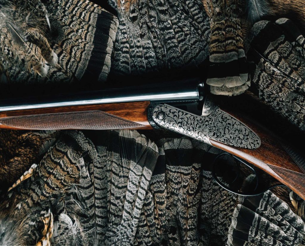 A grouse hunting shotgun with a group of ruffed grouse fans
