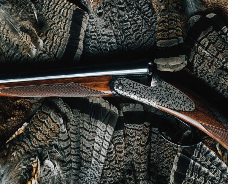 A grouse hunting shotgun with a group of ruffed grouse fans
