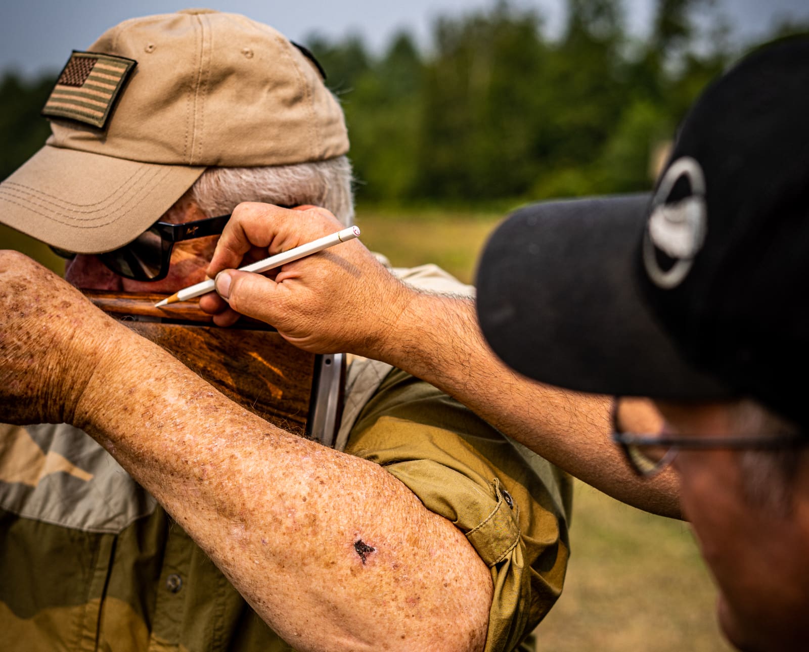 Del Whitman, profession gunfitter marks a gun for measurements with client