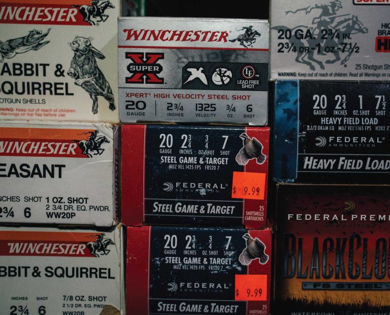 Stack of various shotgun shell boxes in a gun store.