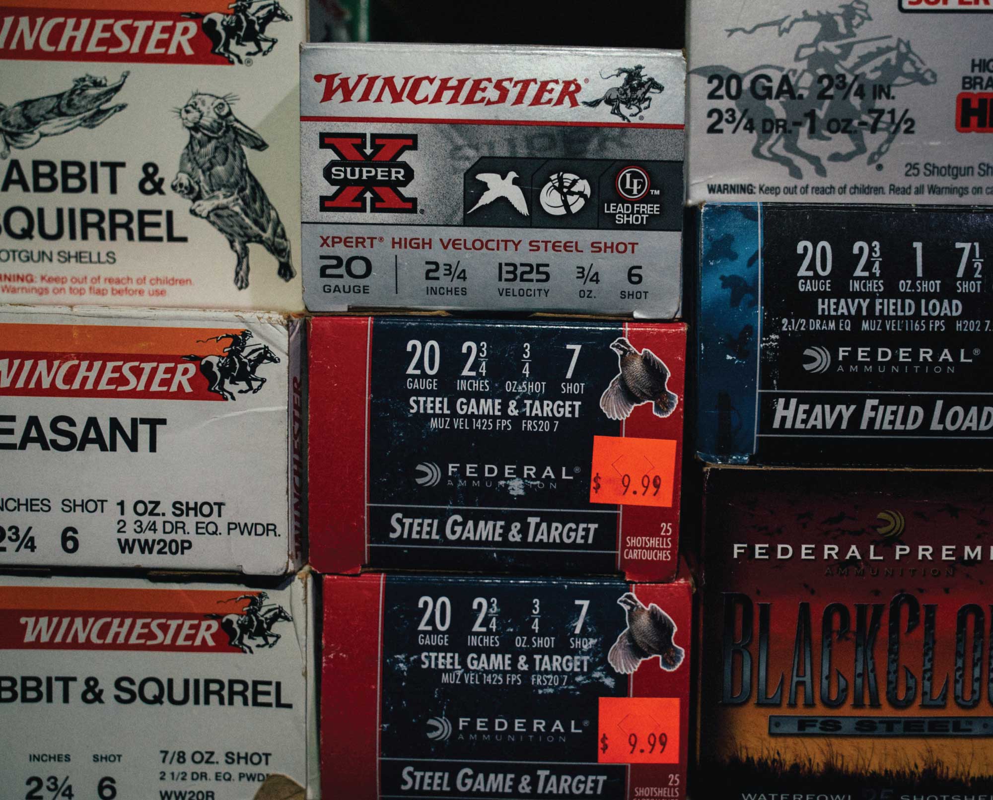 Stack of various shotgun shell boxes in a gun store.