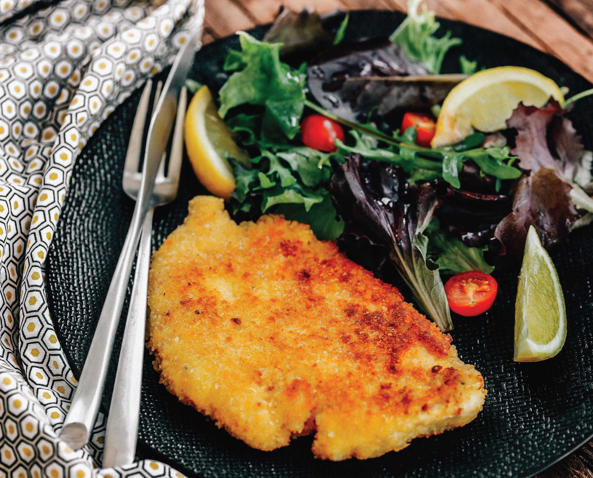 grouse milanese on a plate with salad.