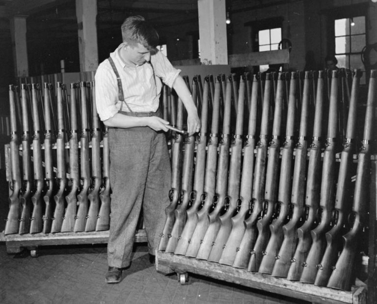 A worker shows a rack of new cooey rifles