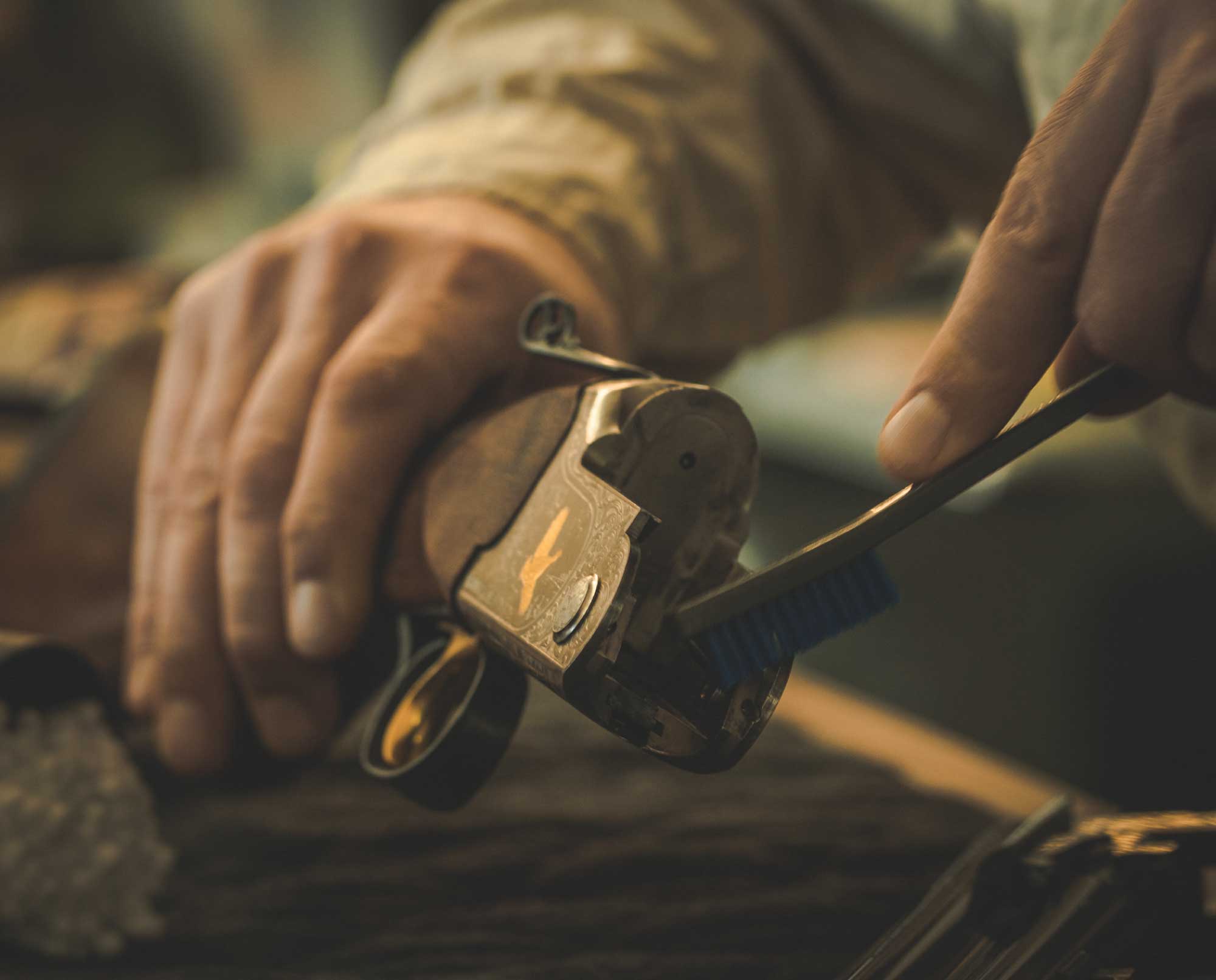 A hunter cleaning a shotgun on a table.