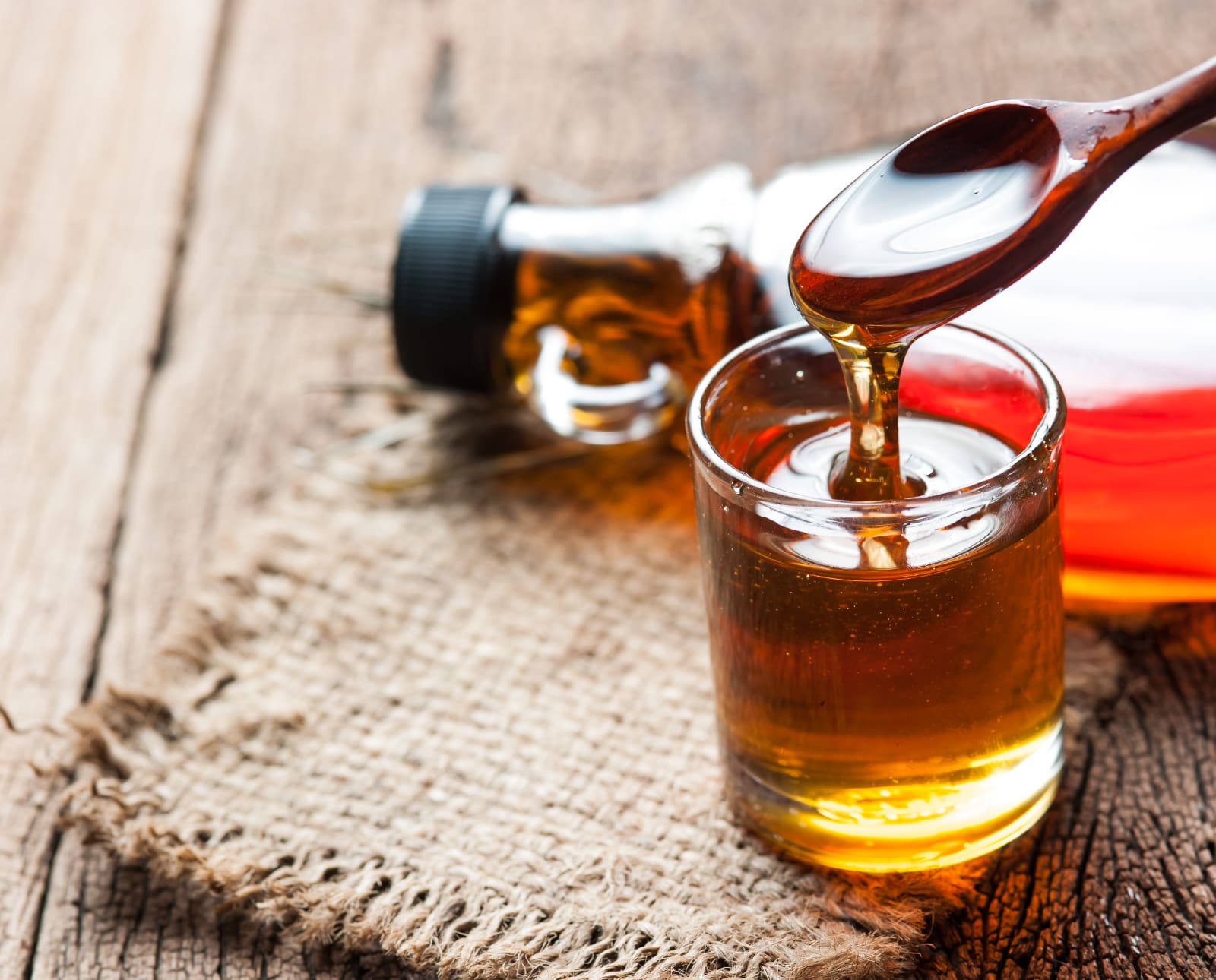 Homemade maple syrup on a table with a botlle.
