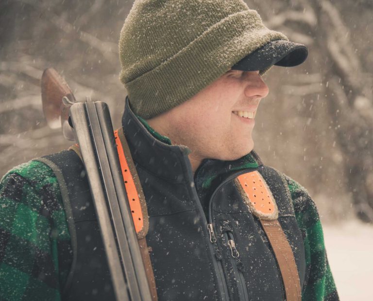 A bird hunter carrying a vintage L.C. Smith shotgun.