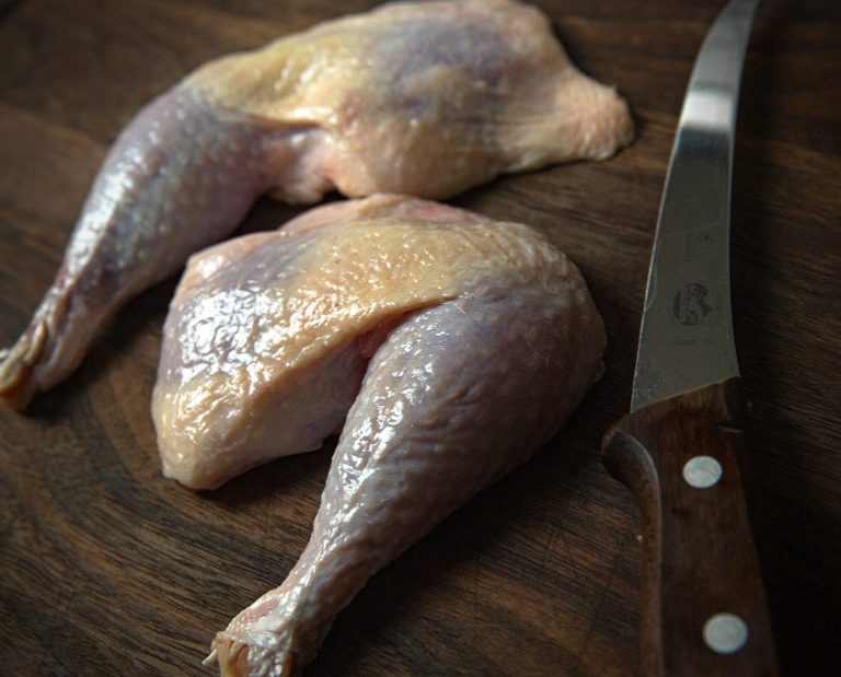 plucked upland bird legs rest on a table.