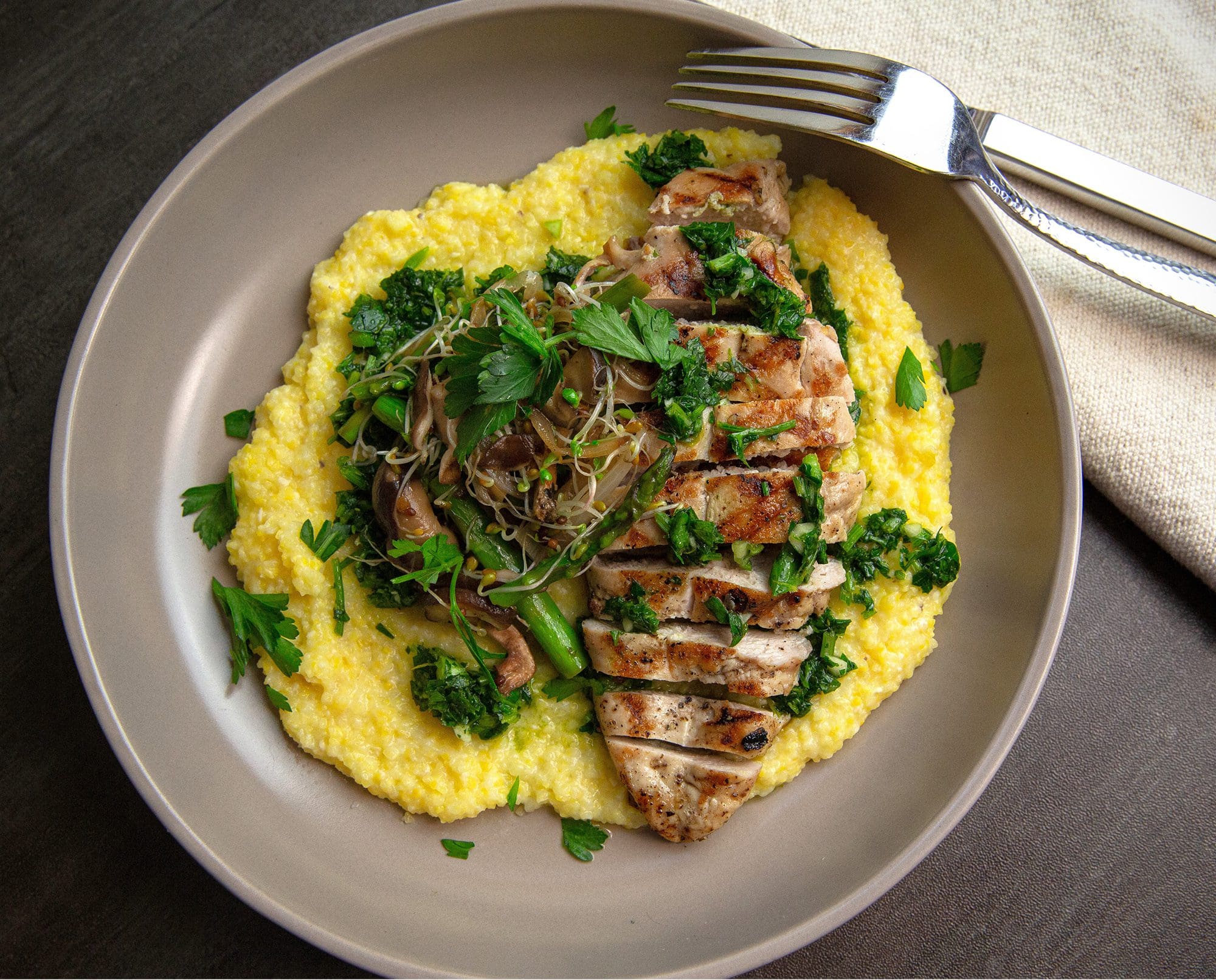 Grilled pheasant rests over polenta.