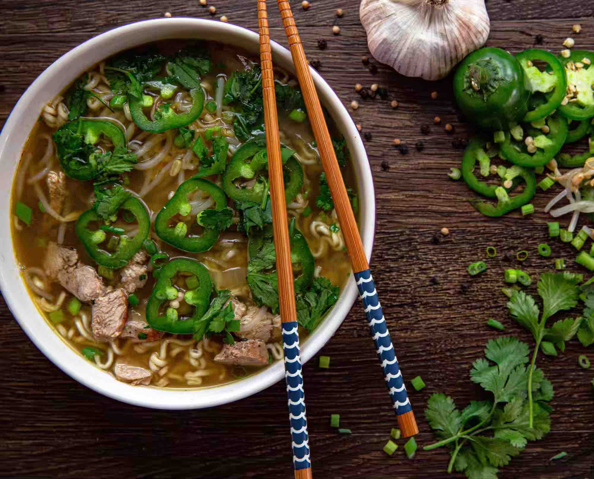a bowl of pheasant pho with chopsticks.