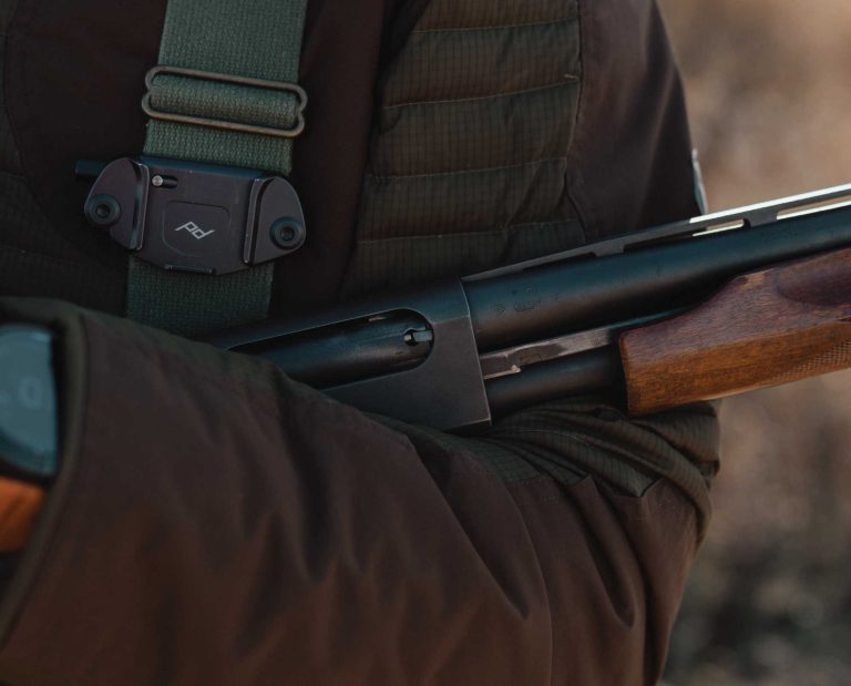 A bird hunter carrying a Remington 870 pump shotgun