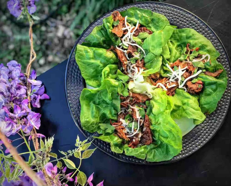 Slow cooked shredded rabbit in lettuce wraps on a plate