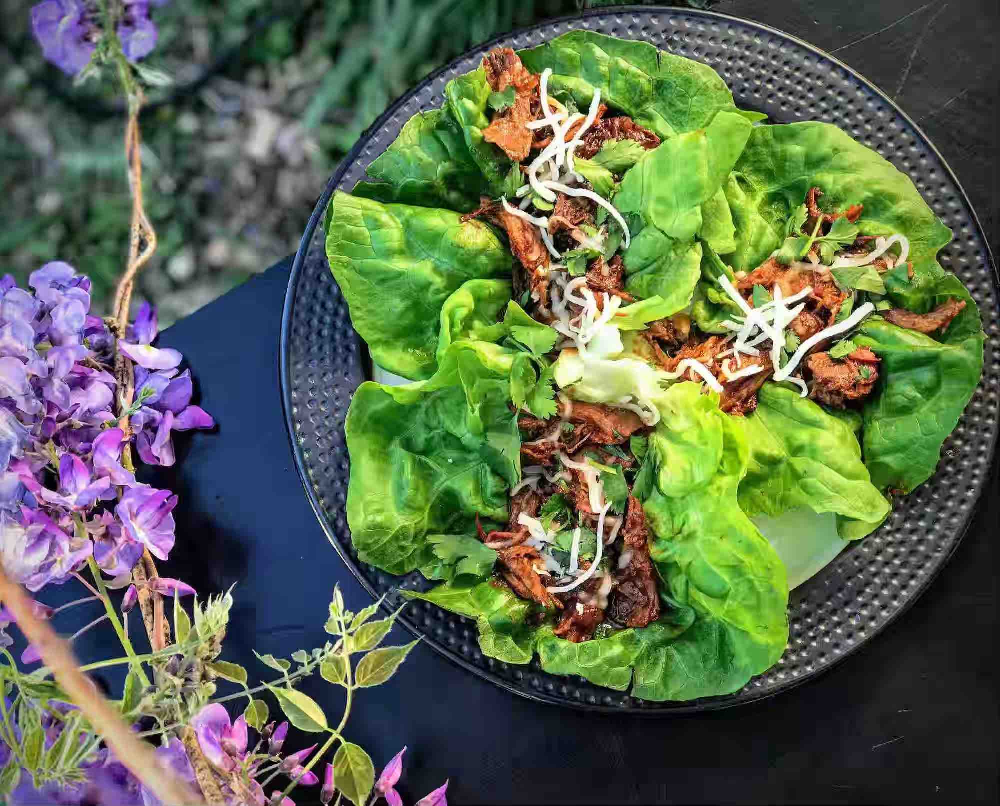 Slow cooked shredded rabbit in lettuce wraps on a plate