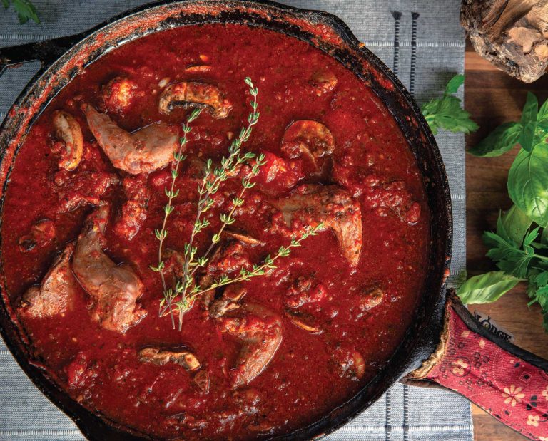 A cast iron skillet of squirrel cacciatore