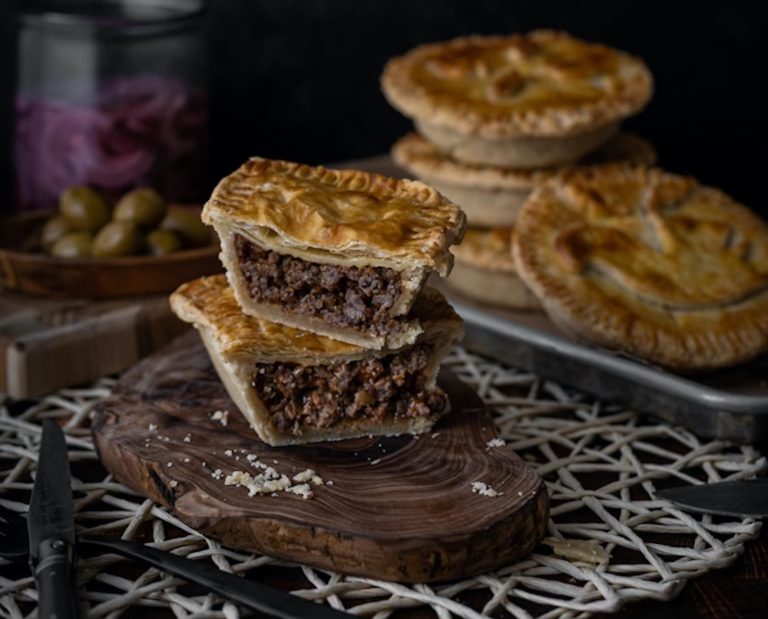 Individual game meat pies displayed on a themed table