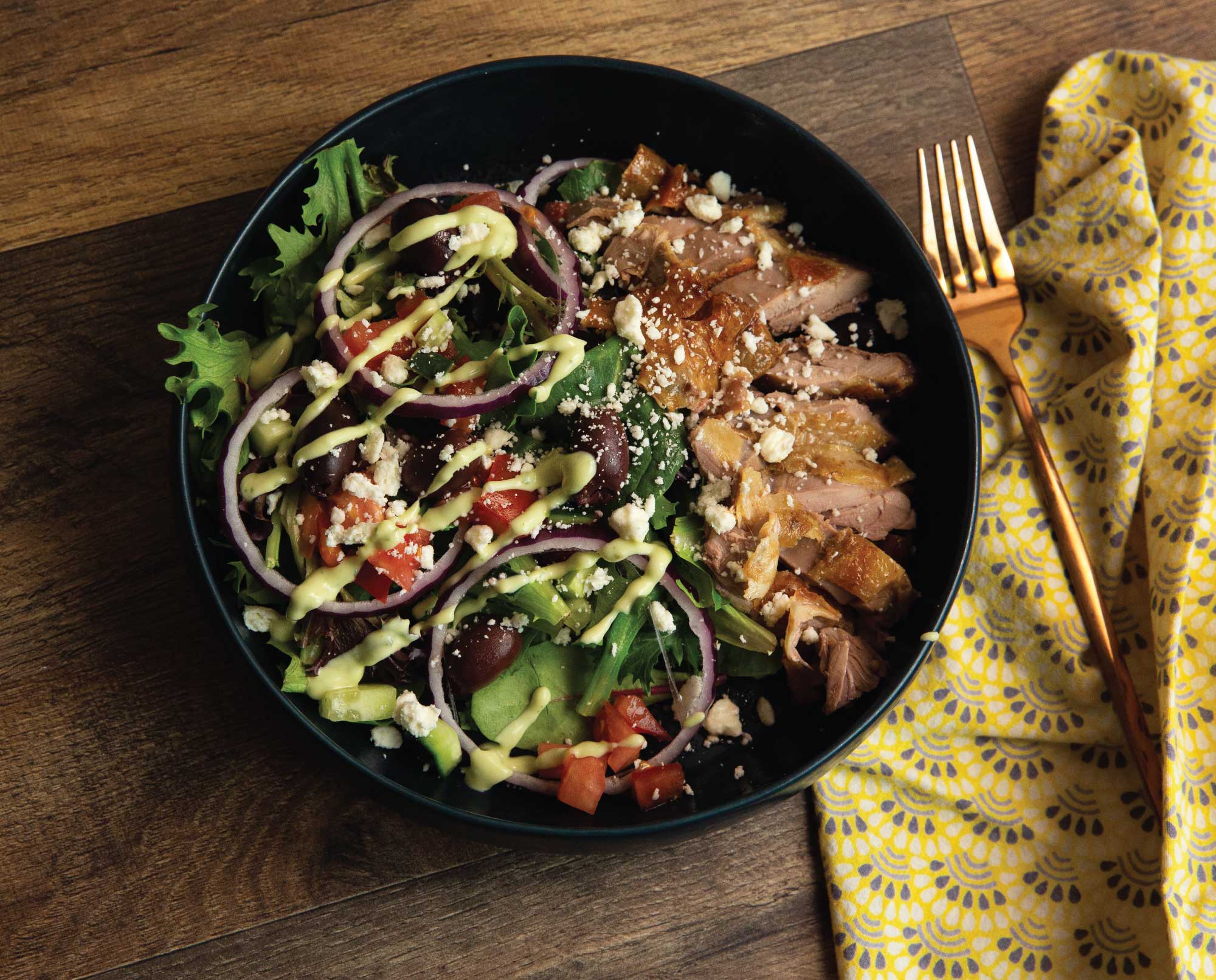 Upland greek salad in a bowl with homemade dressing