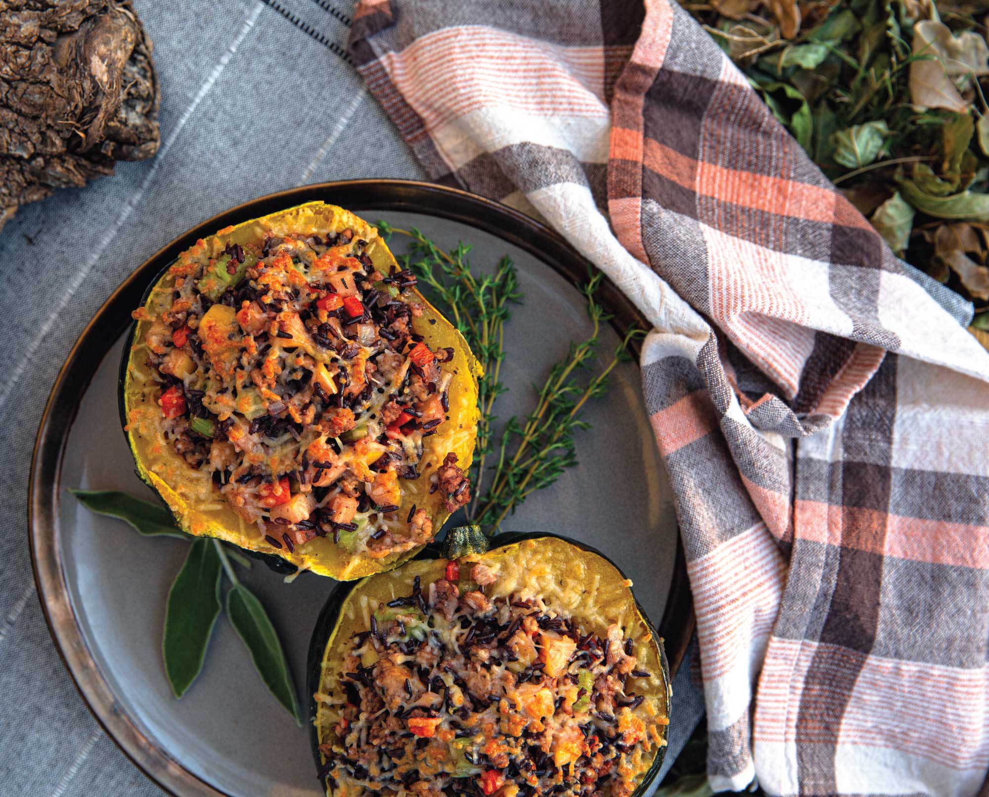 Two halves of stuffed acorn squash on a seasonal plate