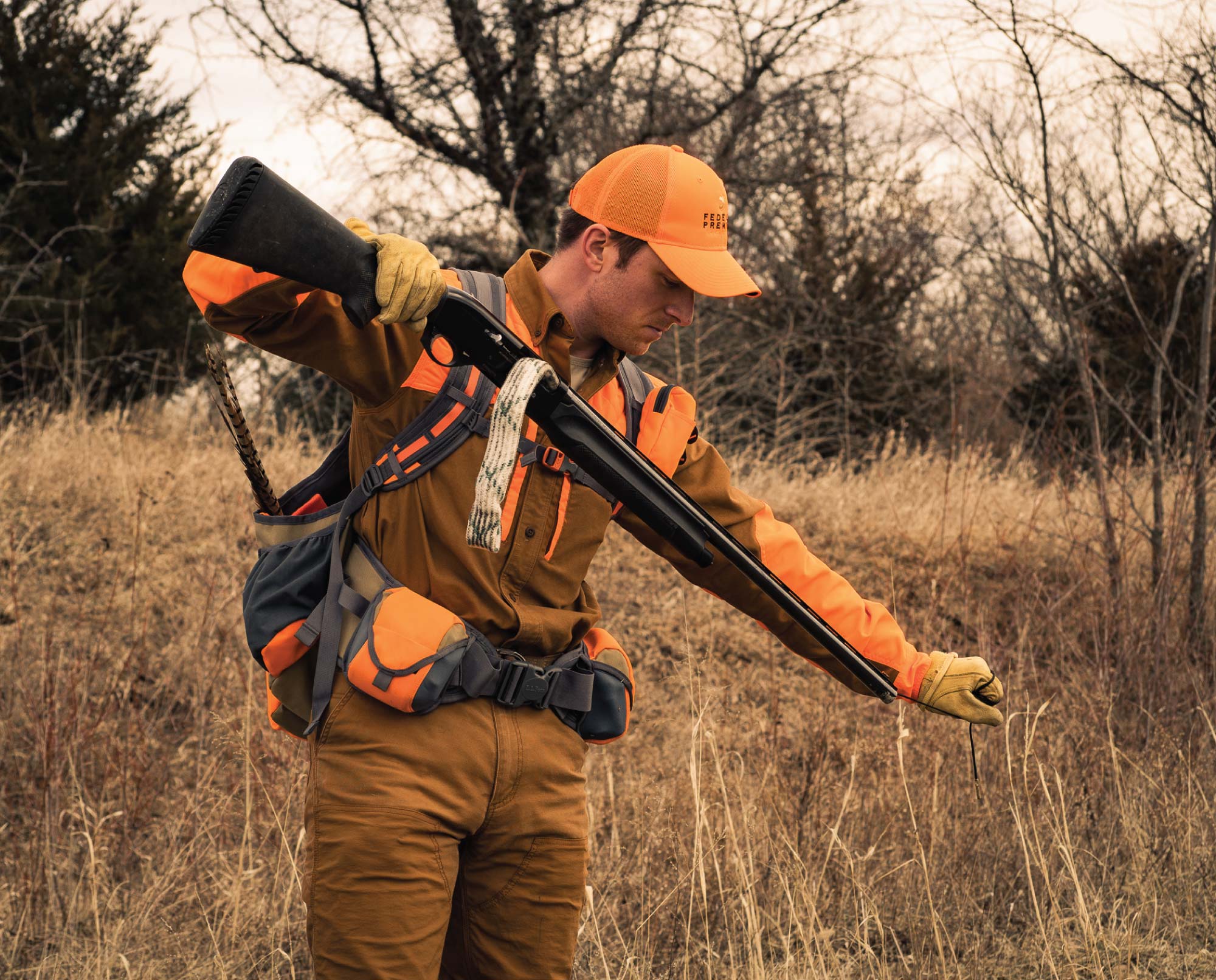 A bird hunter uses a bore snake to clean his shotgun