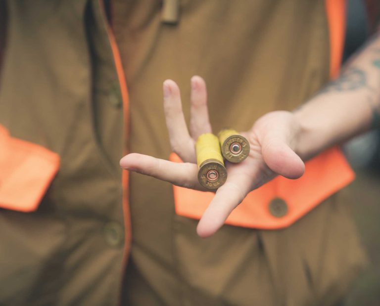 a female bird hunter holding shotgun shells
