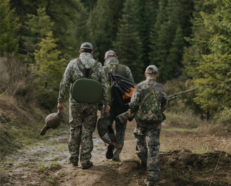 Three turkey hunters walk through the Idaho wilderness.