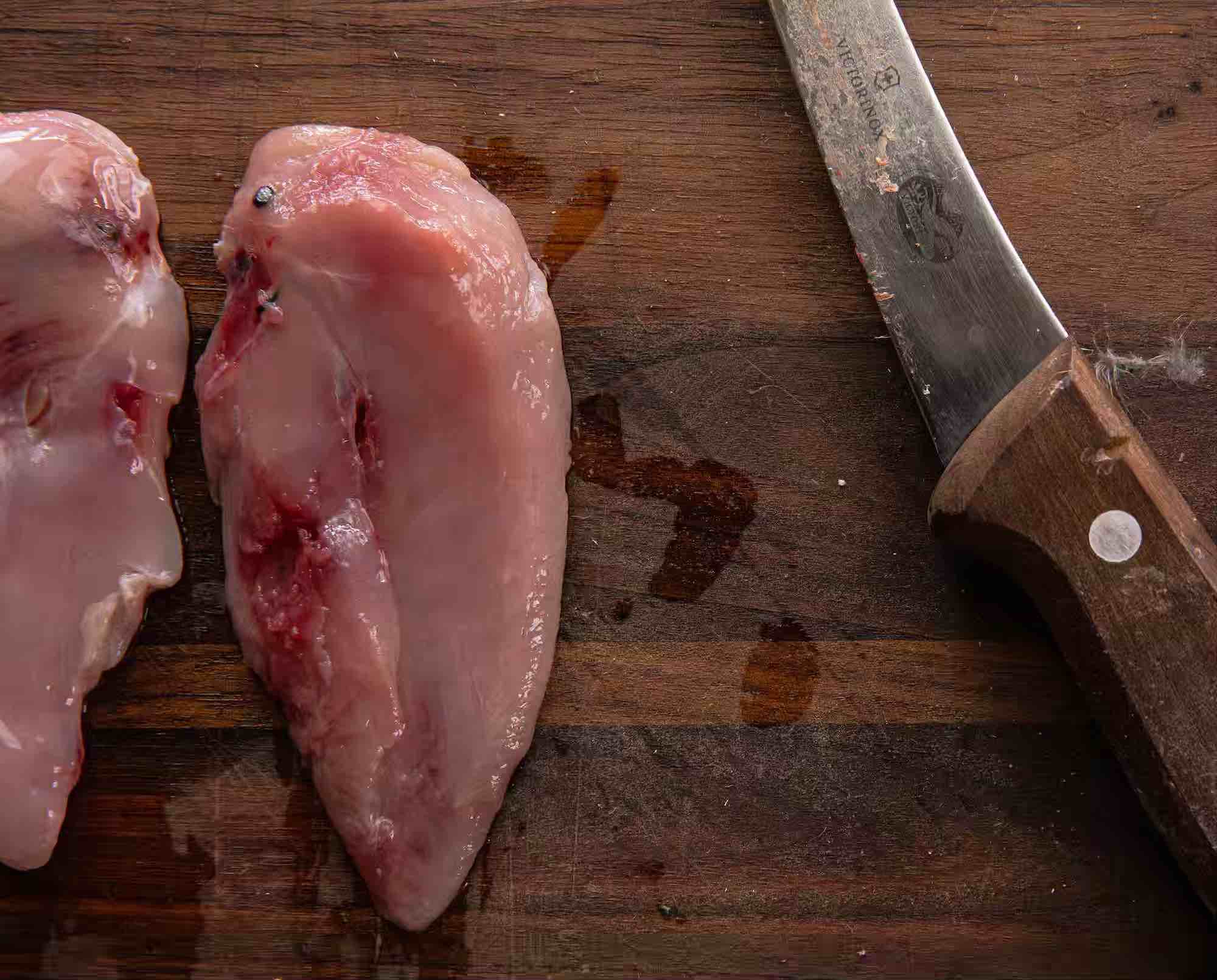 Upland game meat and a knife ona cutting board to remove shot from meat