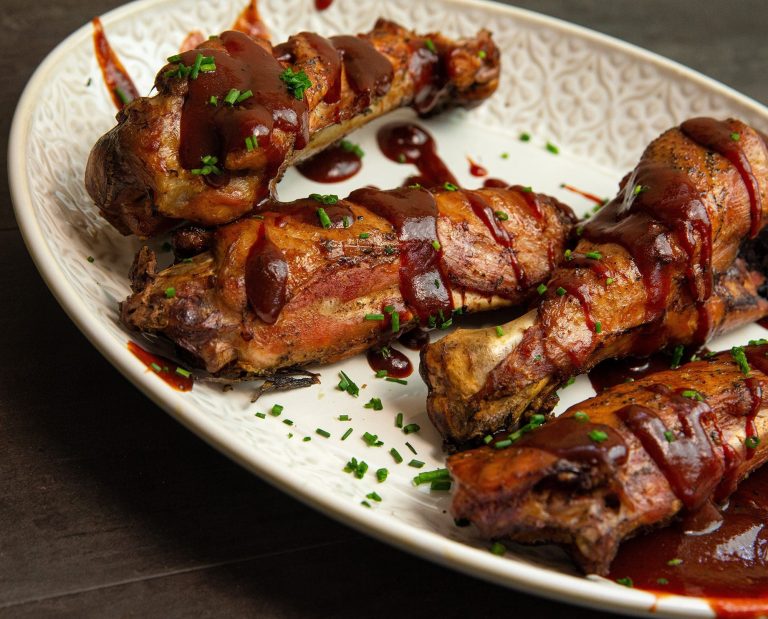 Cooked wild turkey wings rest on a plate.