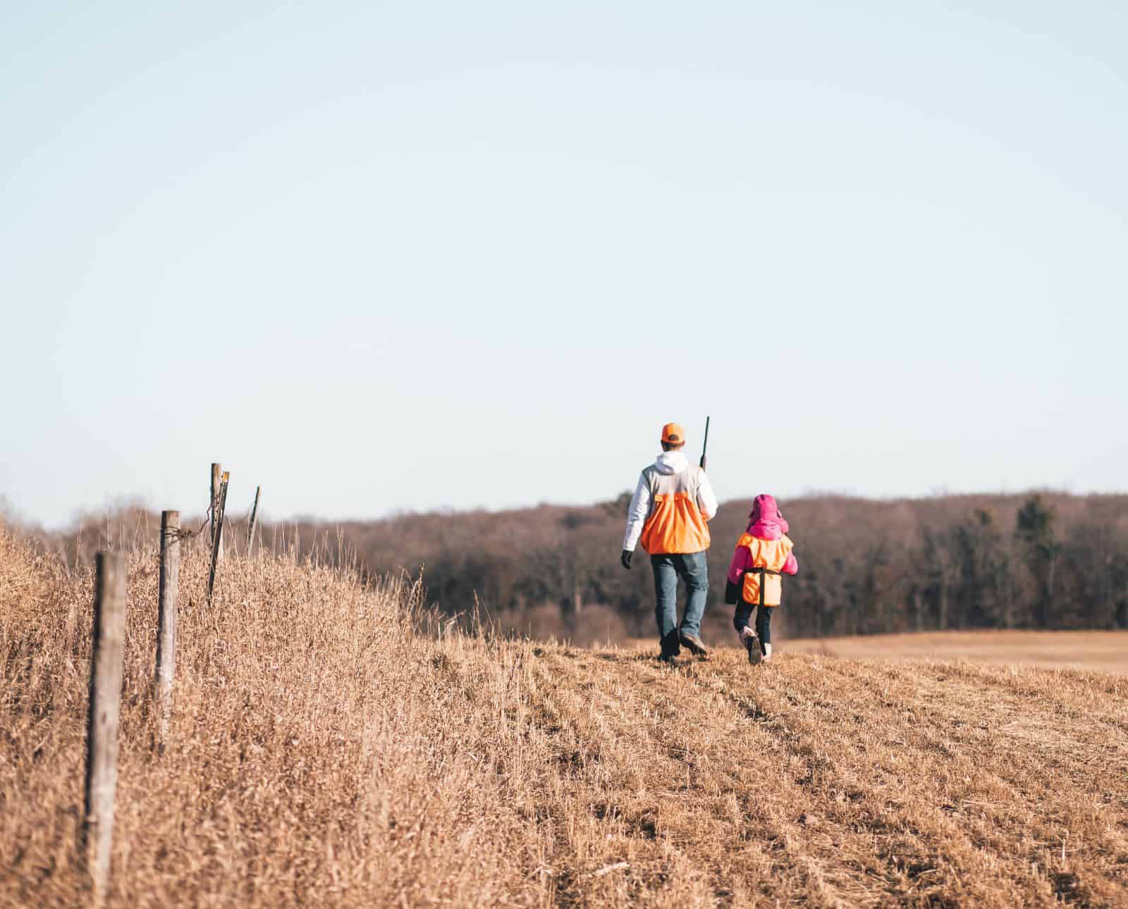 Two hunters walk through a harvested crop field in Ohio.